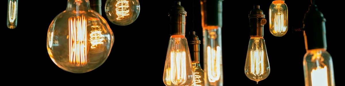 Multiple Edison light bulbs hanging in a dark room